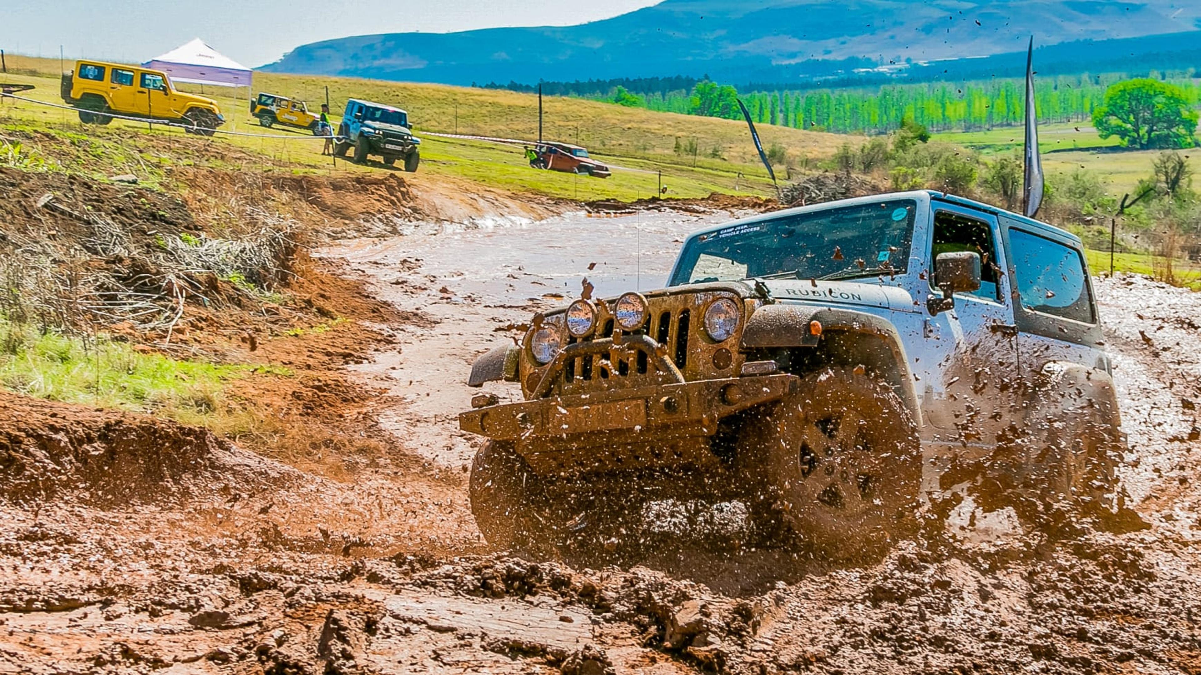 A Jeep Equipped with Mud Tires Splashing Through the Hillside