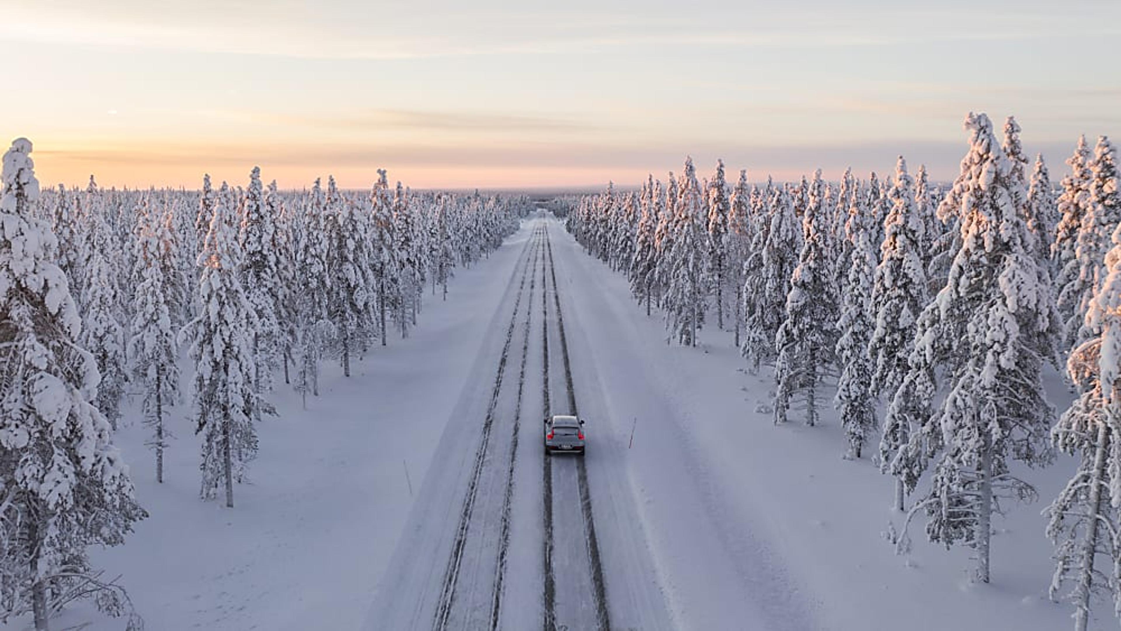 Nokian Hakkapeliitta 10 tires on a passenger car driving away on a snowy day.